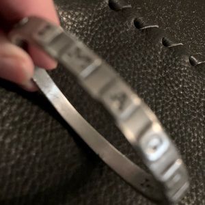 Bracket. Pewter. Imagine is written on outside if bracelet.